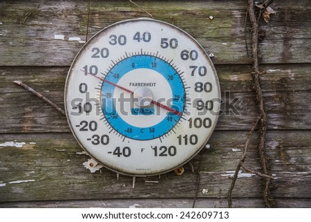 Vintage Thermometer showing 8 degrees fahrenheit on side of barn.
