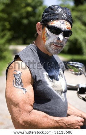 Motorcycle rider with skull face painting and arm painting