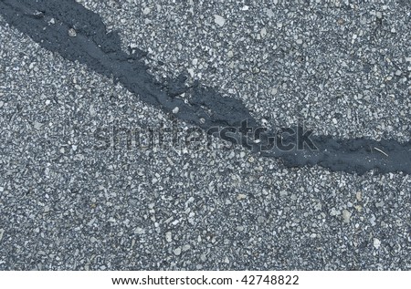 patched cracked road asphalt close up