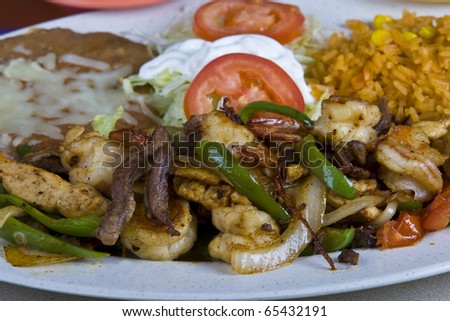 Healthy mexican meal,fajitas and vegetables and rice and beans on plate