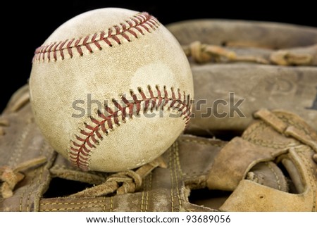 A baseball ball on a glove with black background