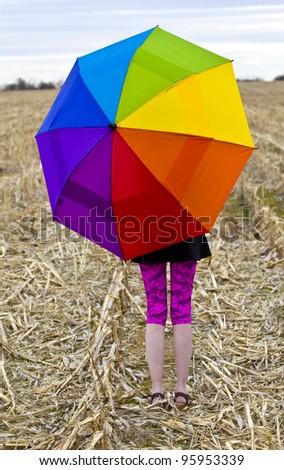 Happy young female  holding an rainbow colored umbrella