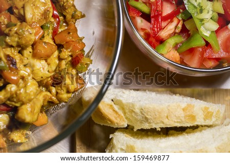 Delicious prepared sliced chicken meet and vegetables with curry in the glass bowl.
