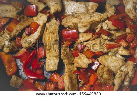Delicious prepared sliced chicken meet and vegetables with curry in the fry pan.