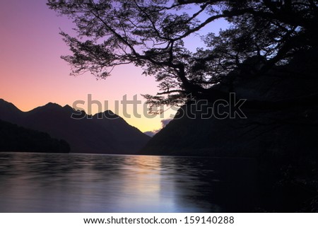 Beautiful mountain lake during sunset in Fiordland National Park, South Island, New Zealand