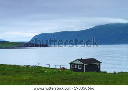Wooden cabin on the shore in Nordic landscape