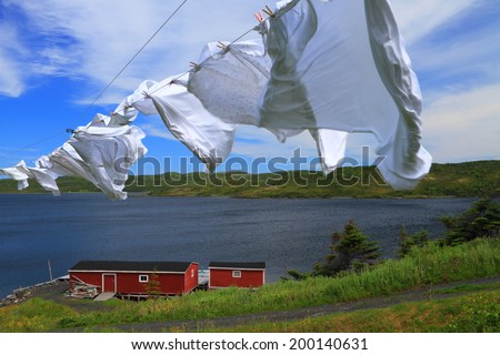 Laundry drying on the clothesline near red cabin in beautiful Nordic landscape