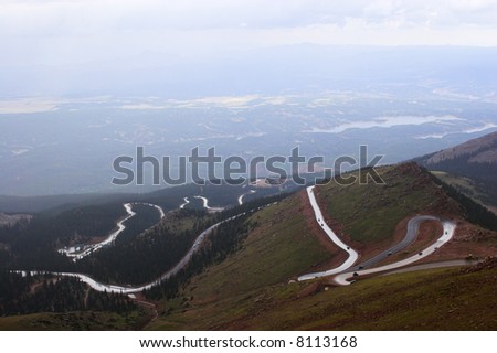 Winding road to Pike’s Peak in Colorado surrounded by colorful mountain prairies during drizzle rain