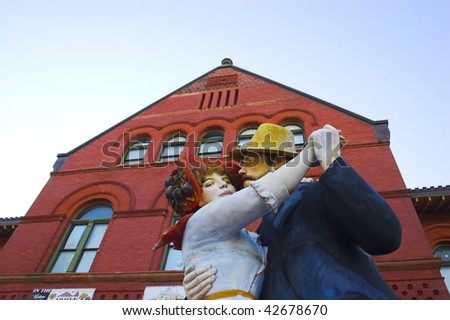 Sculpture of old-fashioned dancing man and woman in front of red building, Key west, Florida