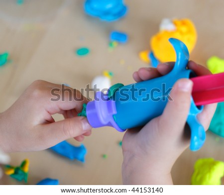 Hands of child working with play dough