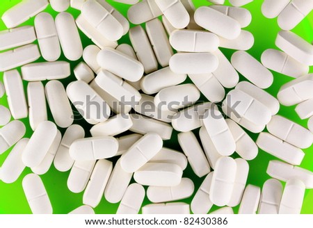 Pile of white pills on green plate