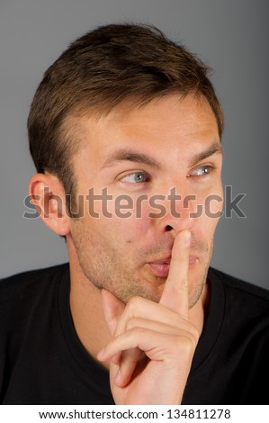 businessman warns about silence, on a gray background