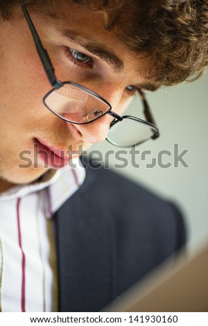 young vigorous businessman works wearing spectacles behind the laptop