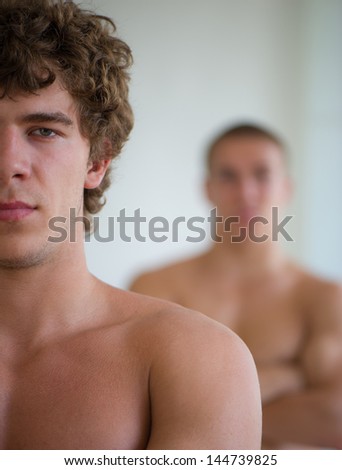 young nice man against other man on a light background
