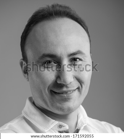 Portrait of a businessman in a shirt looking at the camera and smiling, age thirty-five, thirty-seven years