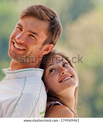Portrait of a happy couple of young people in the park summer day