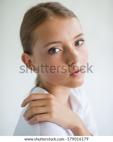 The beautiful young girl. Cute little girl looking at the camera on a light background.