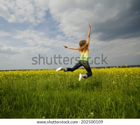 young woman highly has jumped up above  green field