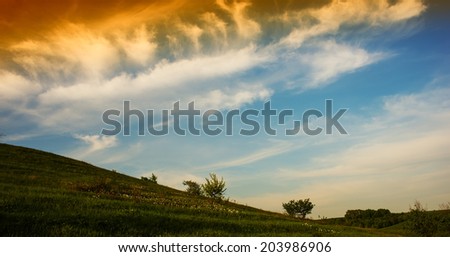 landscape with clouds on a hillside in the countryside, spring season