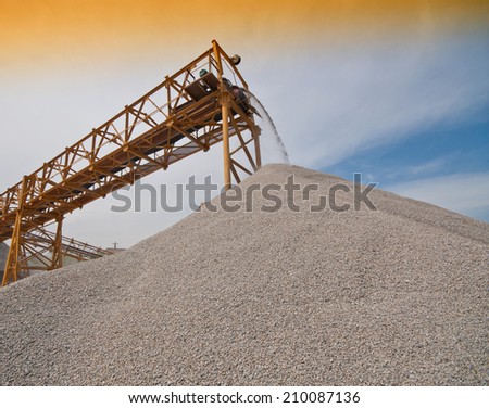delivery of building rubble by a conveyor belt against the sky
