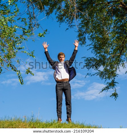 Businessman in white shirt and suit jumped for joy on the street on a sunny day
