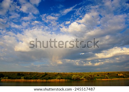 rural landscape, river stones reeds spring season, panorama