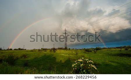 storm clouds and rain rainbow power line, spring landscape