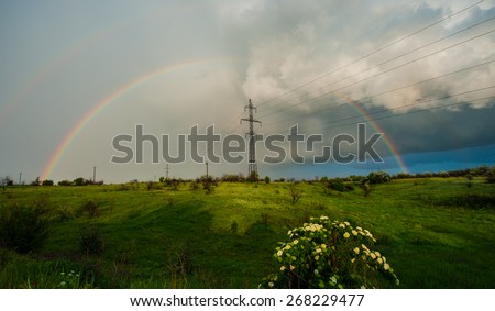 storm clouds and rain rainbow power line, spring landscape