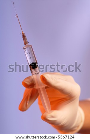 hand in  rubber glove with  syringe