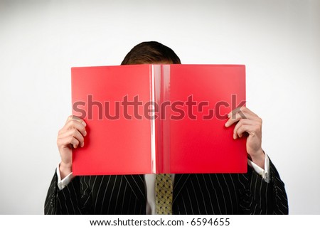 businessman looks  folder of red color with documents on  gray background