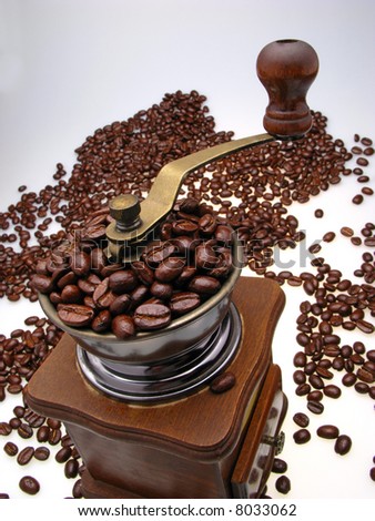 manual coffee-grinder filled with grains of coffee,  close up