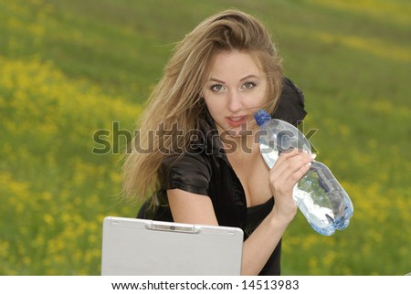 businesswoman works on  computer and drink water in natural conditions