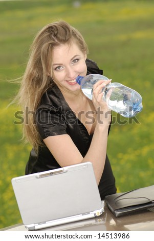 businesswoman works on  computer and drink water in natural conditions