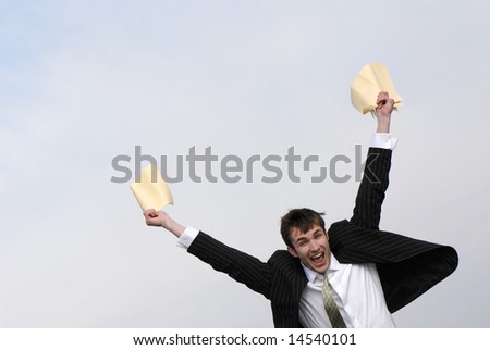 young businessman joyfully waves hands with  paper on  background of  sky