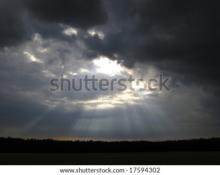 storm sky and solar beams above  wood