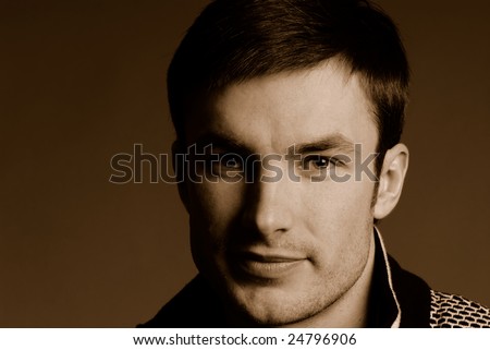 Portrait of  young nice guy in studio on  dark background, close up