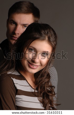 Portrait young nice  guy and  girl on  dark background
