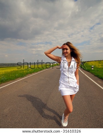 young nice woman goes on road, spring day