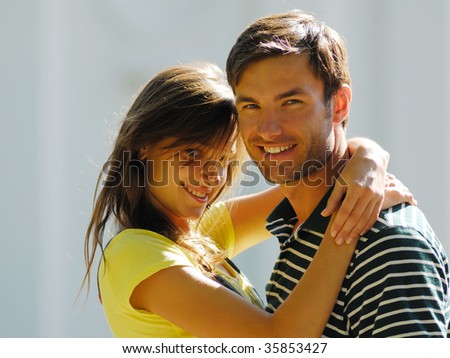 Cheerful pair young people on  light background, summer day