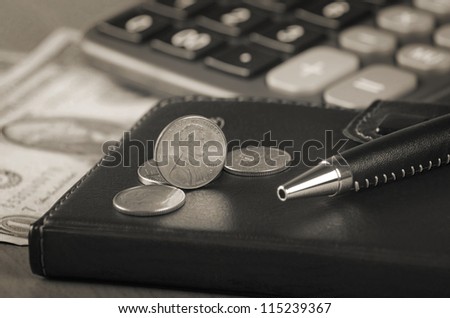 US coins and pen on black note book
