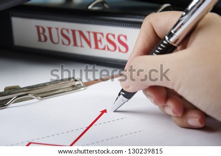 Pointing to a graph in front of business folder