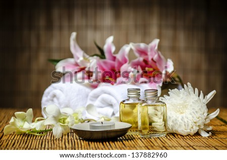 Candle, massage oil, white towels prepared for spa & massage