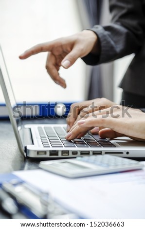 Closeup hand of business person pointing to laptop screen