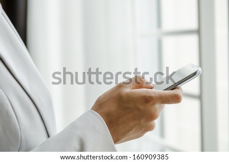 Closeup of hand of woman dialing smart phone