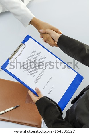 Businesswomen handshaking before signing contract