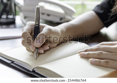 closeup of woman hands taking note