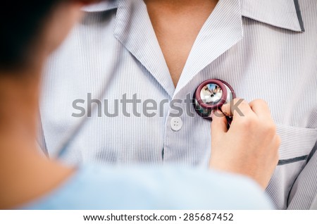 doctor listening to patientâ??s heartbeat with stethoscope