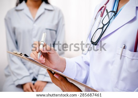doctor writing patientâ??s record after examine health