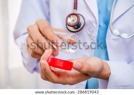 front view of doctor taking medicine on her hand to check