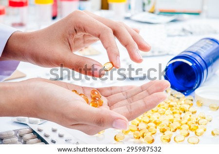 womanâ??s hands holding out fish oil pill